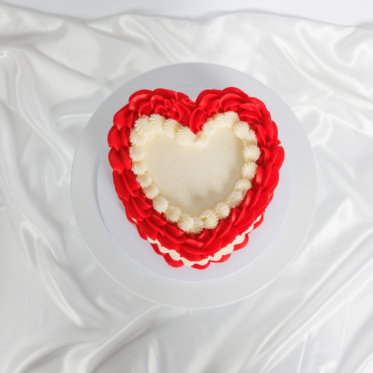 White Vintage Heart Cake with red buttercream trim, top view