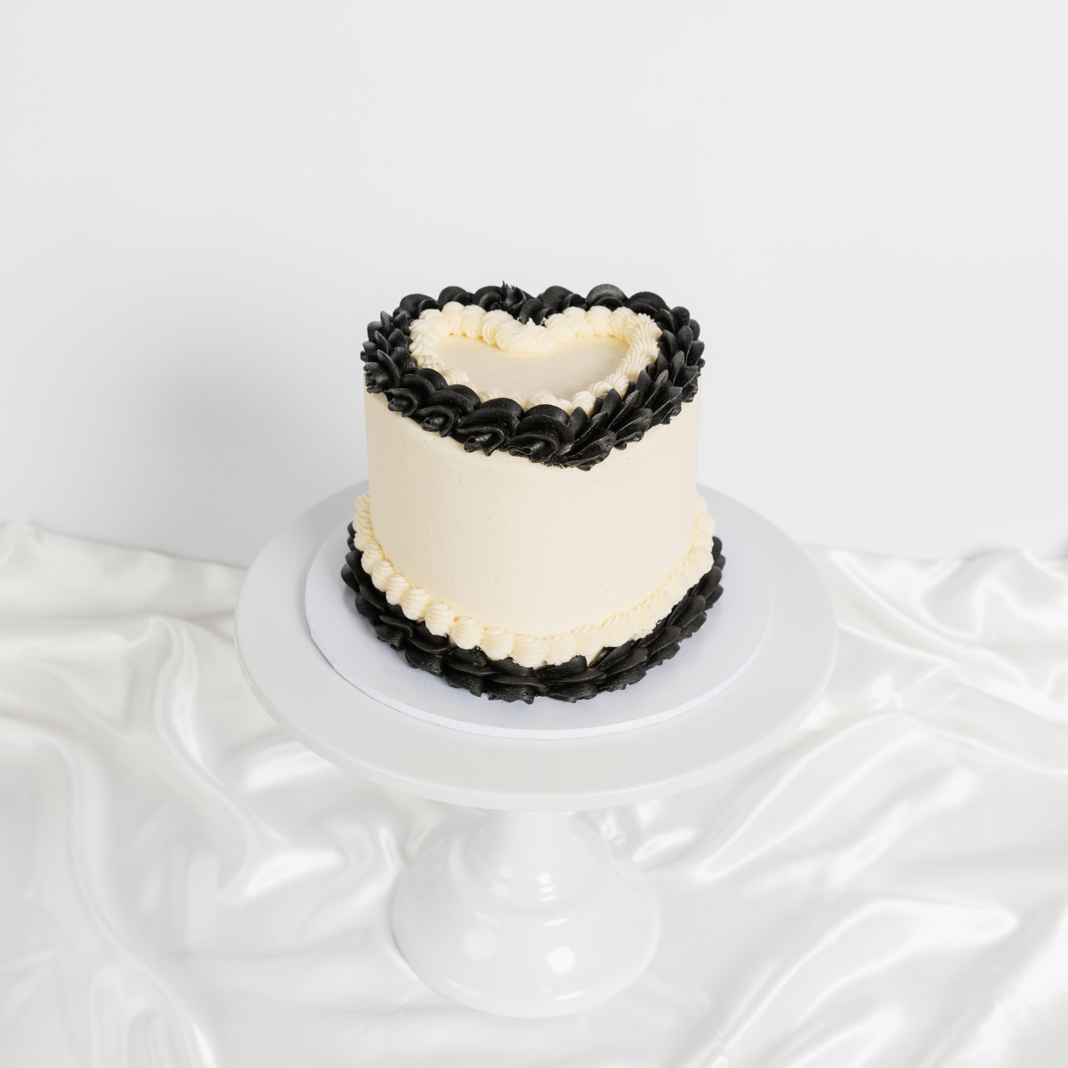 White Vintage Heart Cake with black buttercream trim, side view